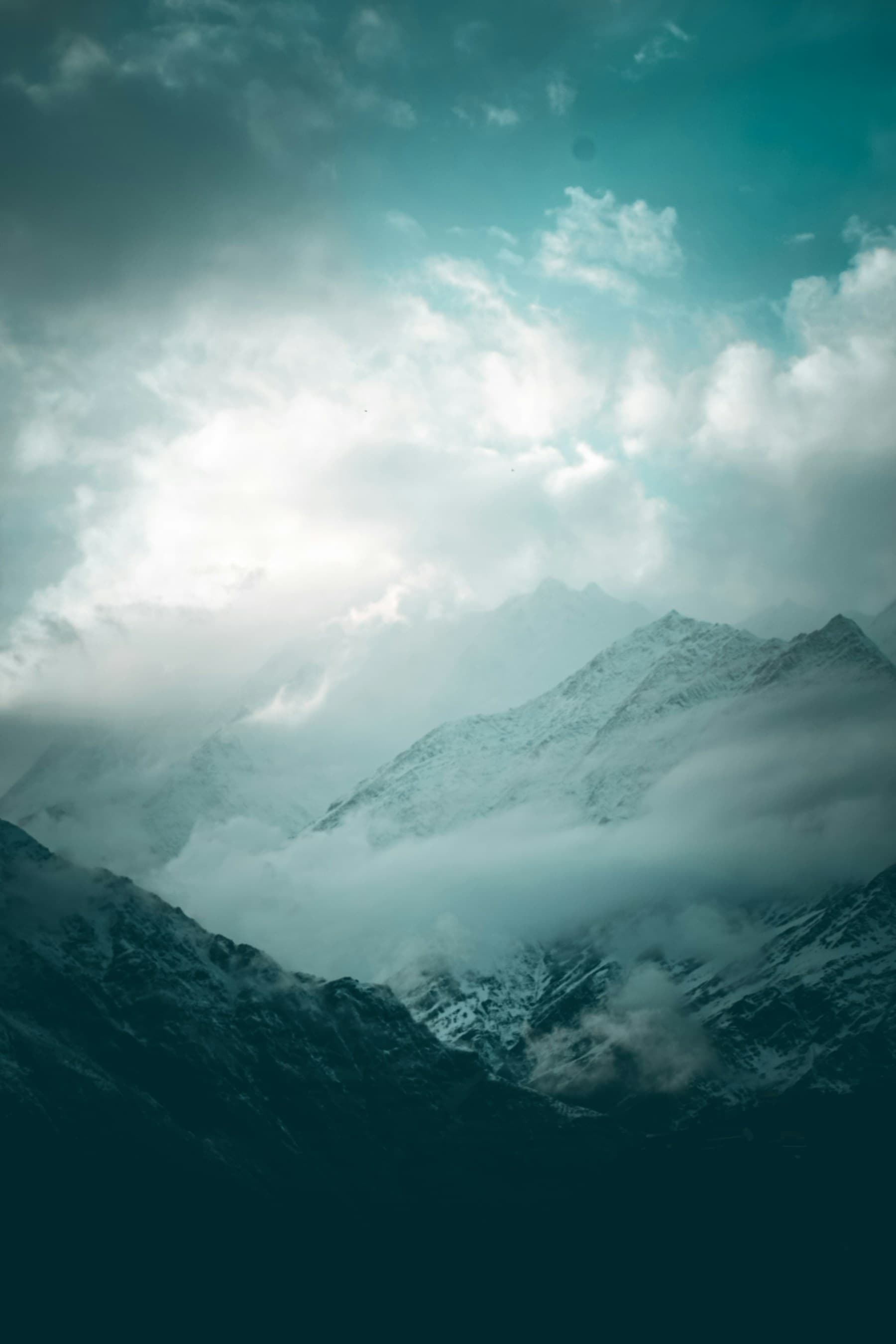 Snow-covered Himalayan peaks rising through layers of cloud