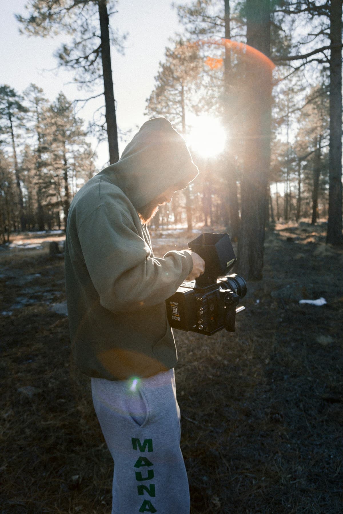 A filmmaker composing a shot with a cinema camera in natural light